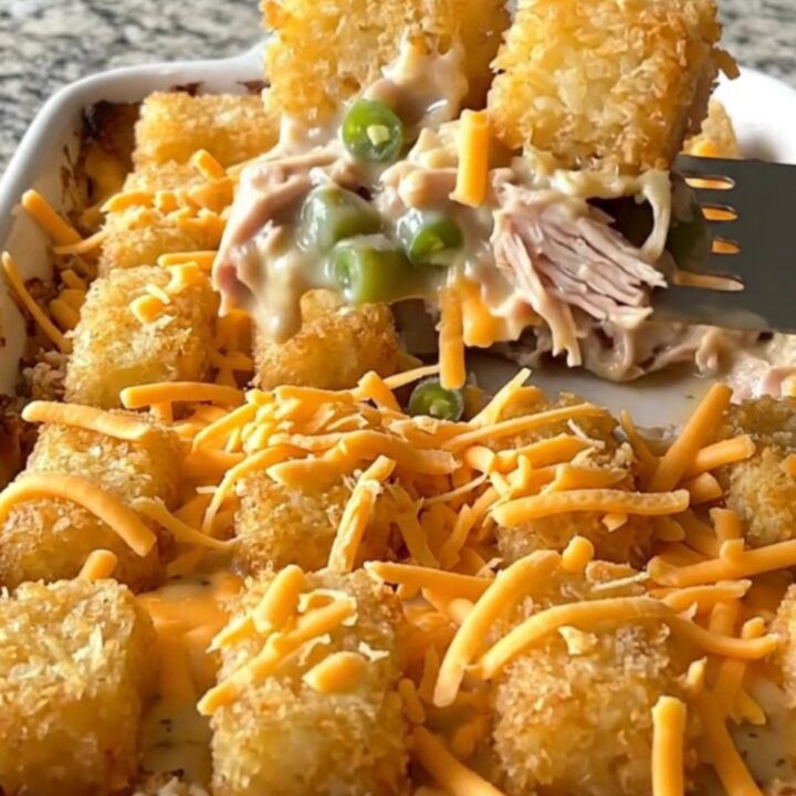 A top-down view of a rectangular baking dish filled with a creamy turkey and green bean base
