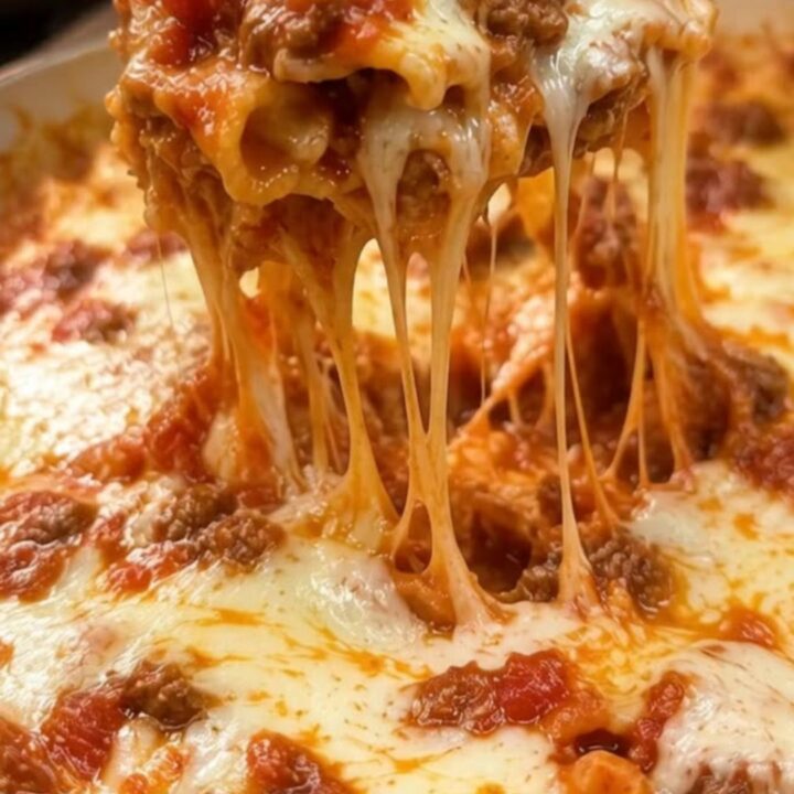 A close-up shot of a steaming, cheesy one-pot lasagna in a cast-iron skillet with a dramatic cheese pull.
