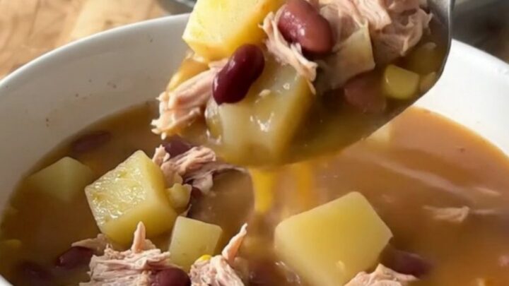A close-up of a bowl of Cowboy Soup with ground turkey, potatoes, and beans in a rich tomato broth.