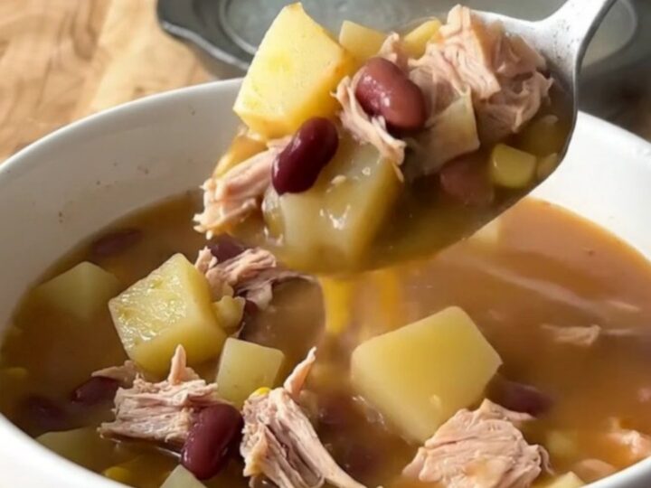 A close-up of a bowl of Cowboy Soup with ground turkey, potatoes, and beans in a rich tomato broth.