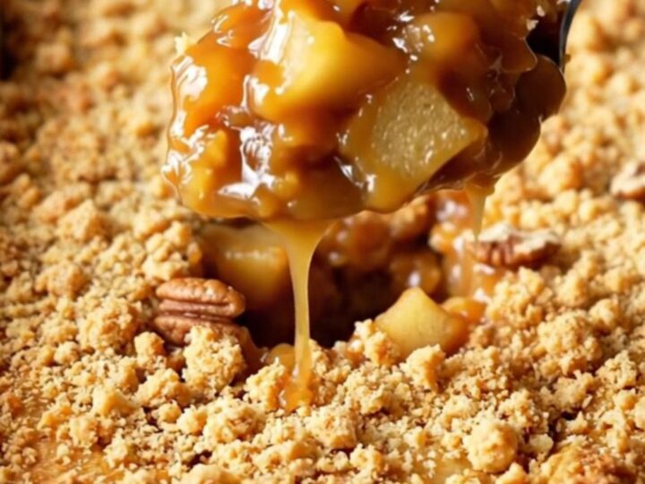 A golden, bubbling salted caramel apple pecan dump cake in a rectangular baking dish.