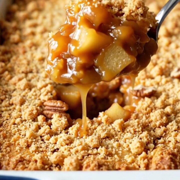 A golden, bubbling salted caramel apple pecan dump cake in a rectangular baking dish.