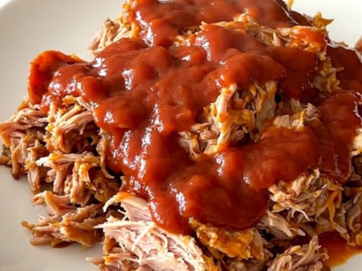 A close-up of a slow cooker filled with ground turkey, pepperoni, and rich red pizza sauce.