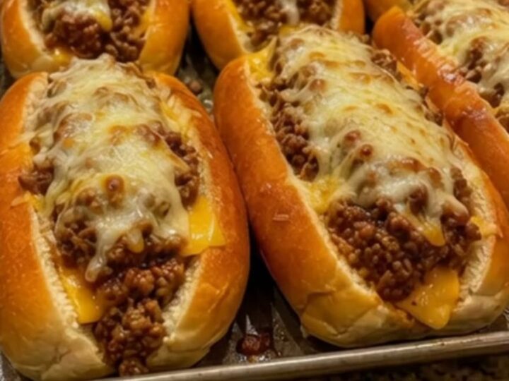 A close-up of a warm, cheesy ground chicken and bell pepper sub with a dramatic cheese pull.