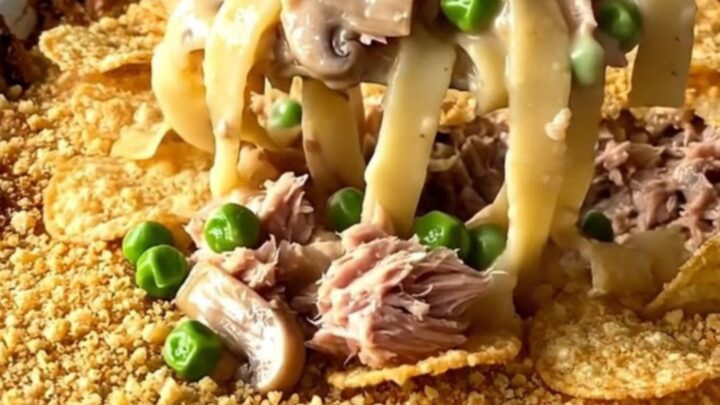 A golden, bubbly tuna noodle bake in a white ceramic dish sitting on a white quartz countertop.