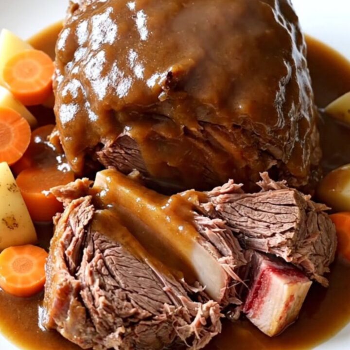 A rustic, slow-cooked Yankee pot roast with chunks of tender beef, carrots, and potatoes in a rich brown gravy.
