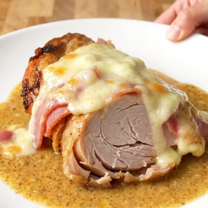A close-up of tender turkey, melted Swiss cheese, and ham in a creamy sauce inside a slow cooker.