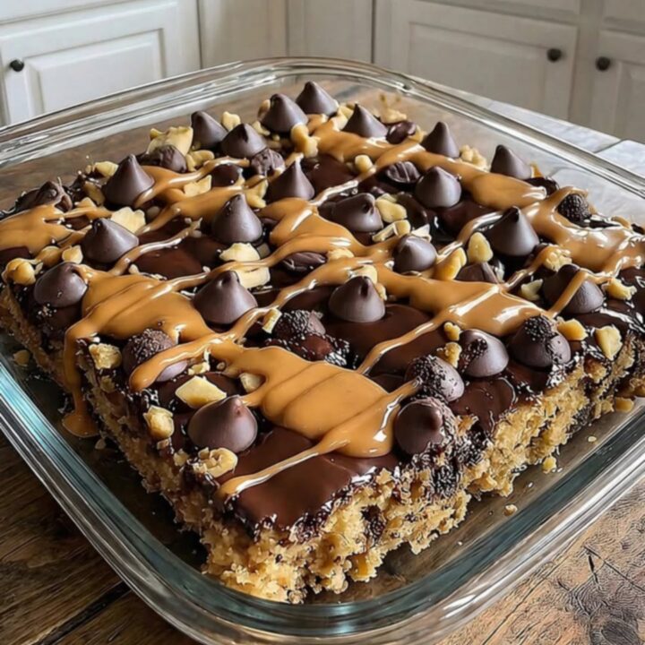 A warm, decadent peanut butter cup dump cake in a rustic square dish with molten chocolate and peanut butter.