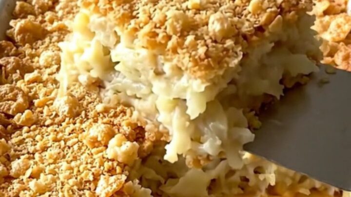 A golden, crunchy-topped funeral potato casserole in a ceramic dish, ready to be served.