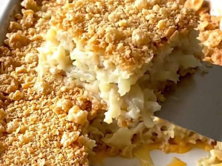 A golden, crunchy-topped funeral potato casserole in a ceramic dish, ready to be served.