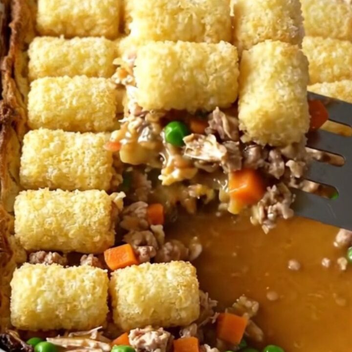 A top-down view of a rectangular baker filled with ground turkey, vegetables, and a golden layer of crispy potato tots.