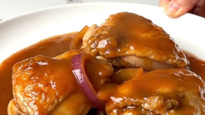 A top-down view of tender maple sriracha chicken thighs in a slow cooker insert.