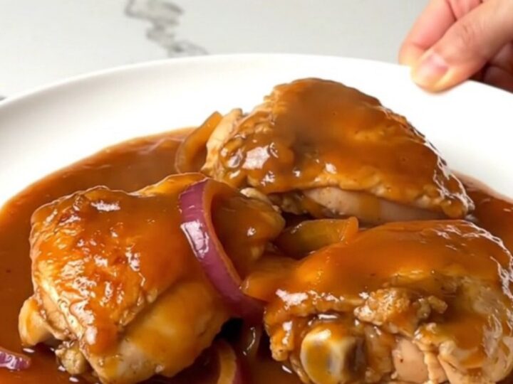A top-down view of tender maple sriracha chicken thighs in a slow cooker insert.