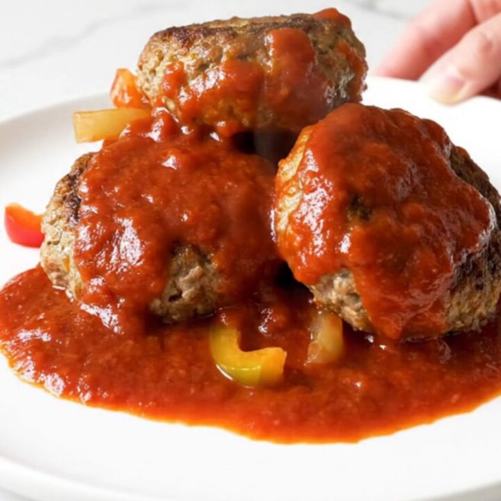 Four golden-brown turkey patties arranged in a ring inside a black slow cooker