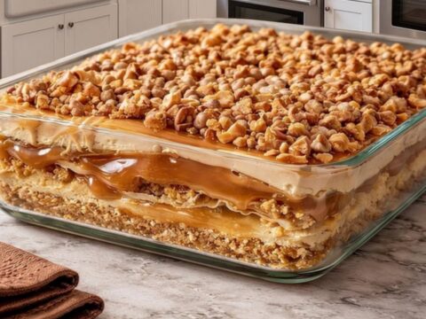 A beautiful view of the Peanut Butter Crunch Lasagna in a glass dish showing distinct layers.