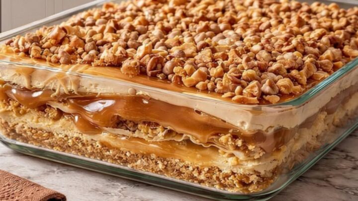 A beautiful view of the Peanut Butter Crunch Lasagna in a glass dish showing distinct layers.