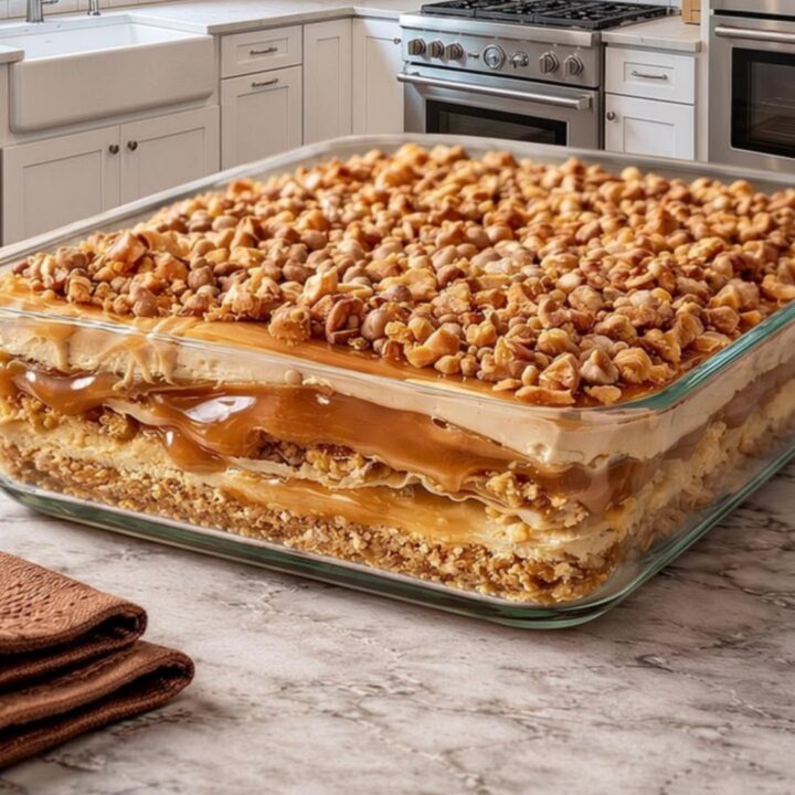 A beautiful view of the Peanut Butter Crunch Lasagna in a glass dish showing distinct layers.