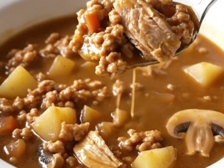 A bowl of ground turkey Salisbury steak soup with mushrooms and potatoes.
