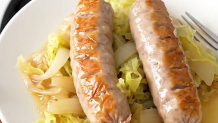 A top-down view of six raw bratwurst links arranged in a slow cooker with cabbage wedges and onions.