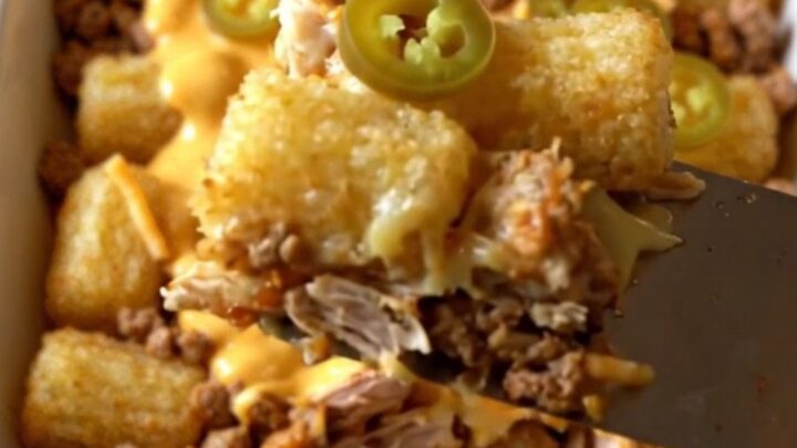 A top-down view of a rectangular ceramic baking dish filled with seasoned ground turkey and crispy potato tots.
