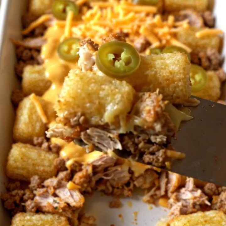 A top-down view of a rectangular ceramic baking dish filled with seasoned ground turkey and crispy potato tots.