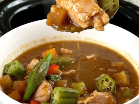 A bowl of chicken and okra gumbo served over rice with steam rising from the dish.