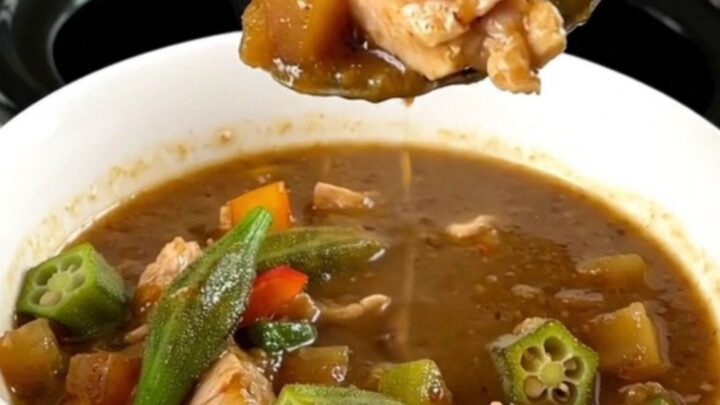 A bowl of chicken and okra gumbo served over rice with steam rising from the dish.
