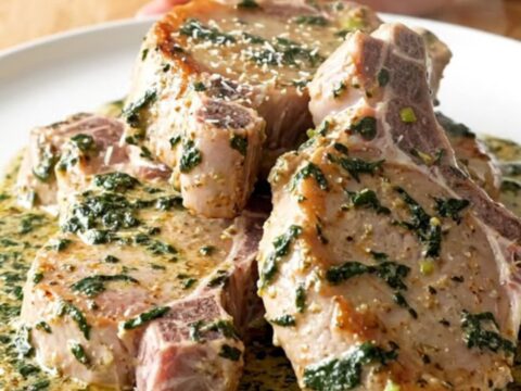 Slow cooker filled with tender pork chops smothered in a creamy spinach and artichoke sauce.