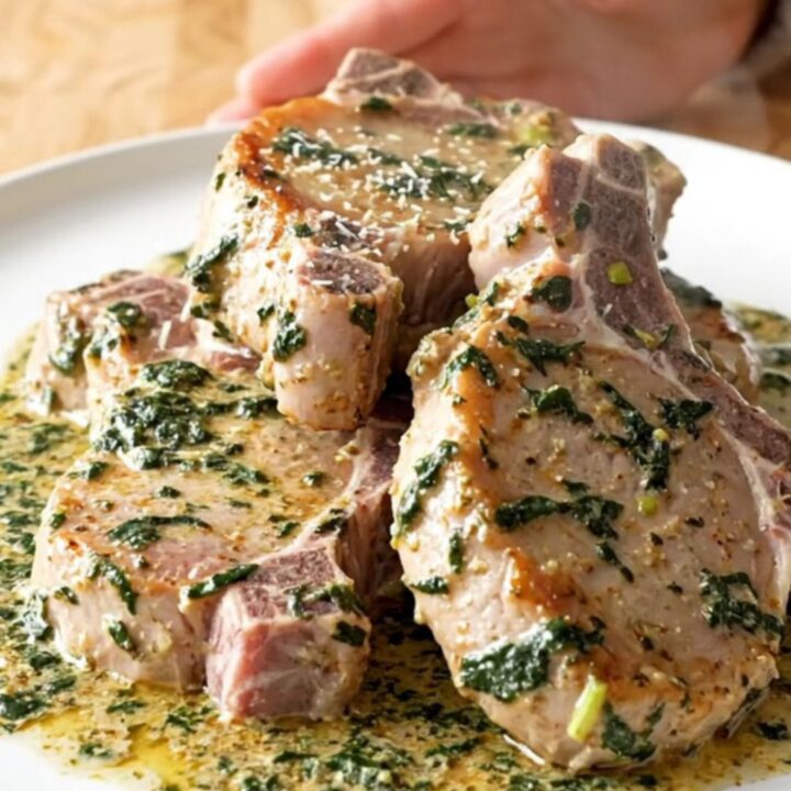 Slow cooker filled with tender pork chops smothered in a creamy spinach and artichoke sauce.