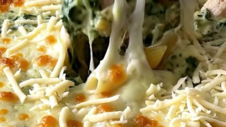 A top-down view of a rectangular baking dish filled with creamy chicken florentine pasta ready for the oven.