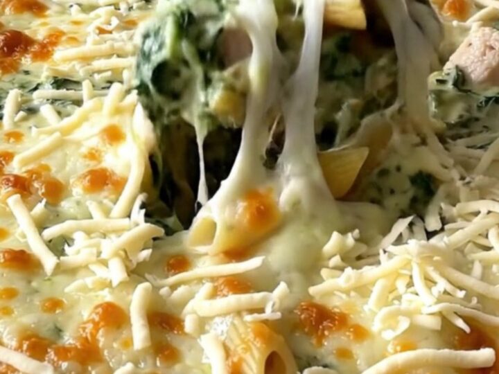 A top-down view of a rectangular baking dish filled with creamy chicken florentine pasta ready for the oven.