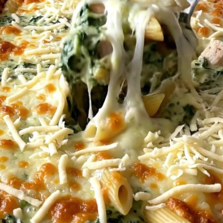 A top-down view of a rectangular baking dish filled with creamy chicken florentine pasta ready for the oven.