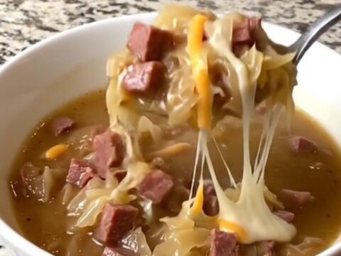 A rustic bowl of creamy Reuben soup filled with corned beef and sauerkraut.