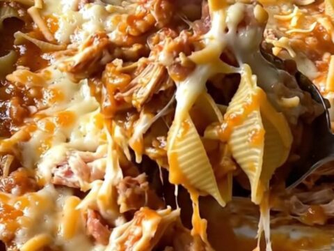 A top-down view of a rectangular baking dish filled with pasta shells, ground turkey, and melted cheese.