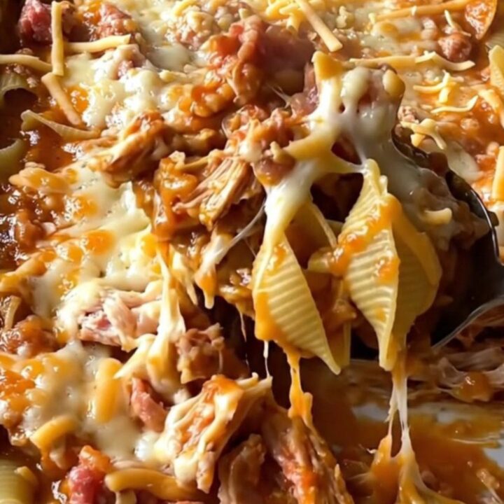 A top-down view of a rectangular baking dish filled with pasta shells, ground turkey, and melted cheese.