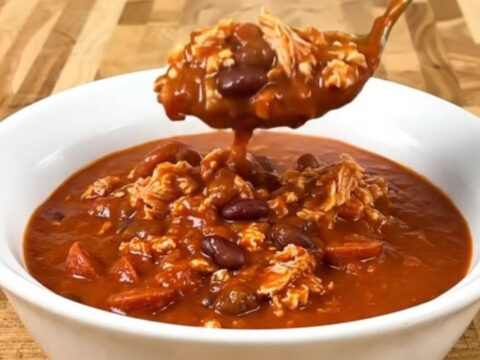 A bowl of Turkey Pizza Chili served in a white bowl with visible turkey, beans, and pepperoni.