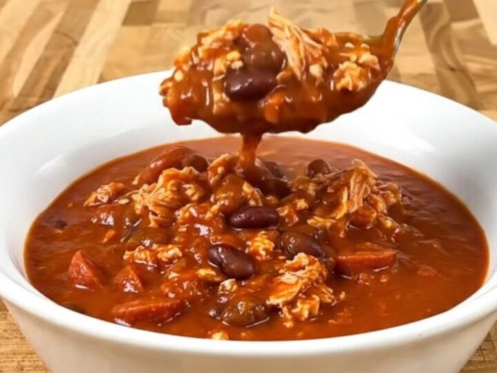 A bowl of Turkey Pizza Chili served in a white bowl with visible turkey, beans, and pepperoni.