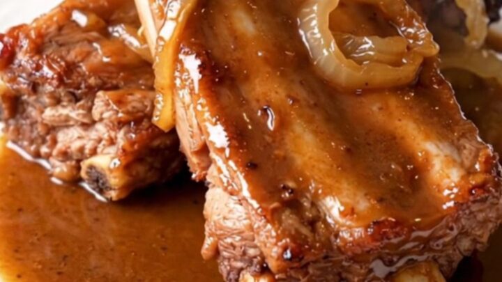 A close-up of tender, slow-cooked baby back ribs in a crockpot with a savory brown sugar and beer glaze.