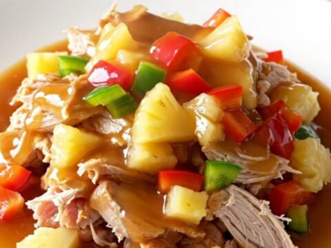 A close-up of slow cooker sweet and sour ground turkey served on a white plate with visible pineapple chunks and bell