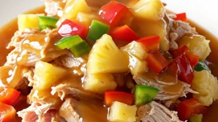 A close-up of slow cooker sweet and sour ground turkey served on a white plate with visible pineapple chunks and bell
