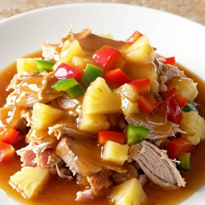A close-up of slow cooker sweet and sour ground turkey served on a white plate with visible pineapple chunks and bell