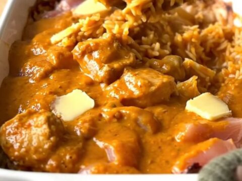 A large rectangular ceramic dish filled with creamy butter chicken and rice, fresh from the oven.