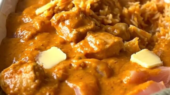 A large rectangular ceramic dish filled with creamy butter chicken and rice, fresh from the oven.