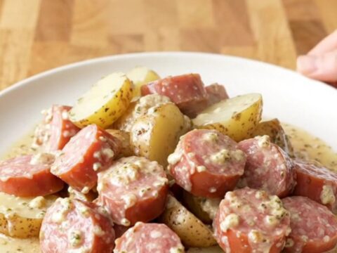 A close-up of creamy garlic Italian sausage and potatoes in a slow cooker.