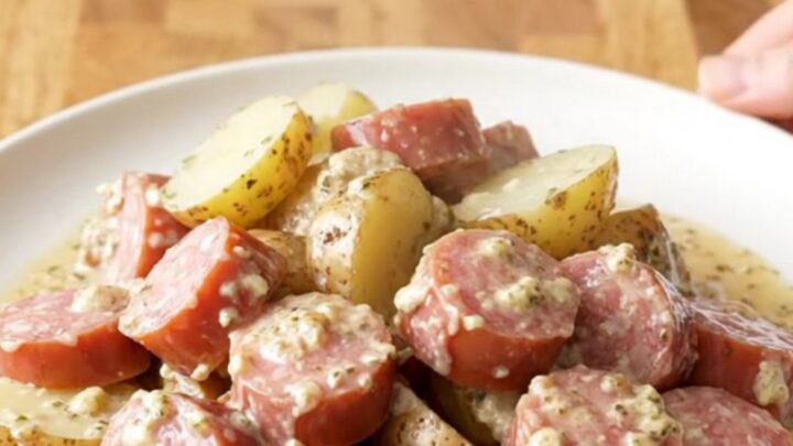 A close-up of creamy garlic Italian sausage and potatoes in a slow cooker.
