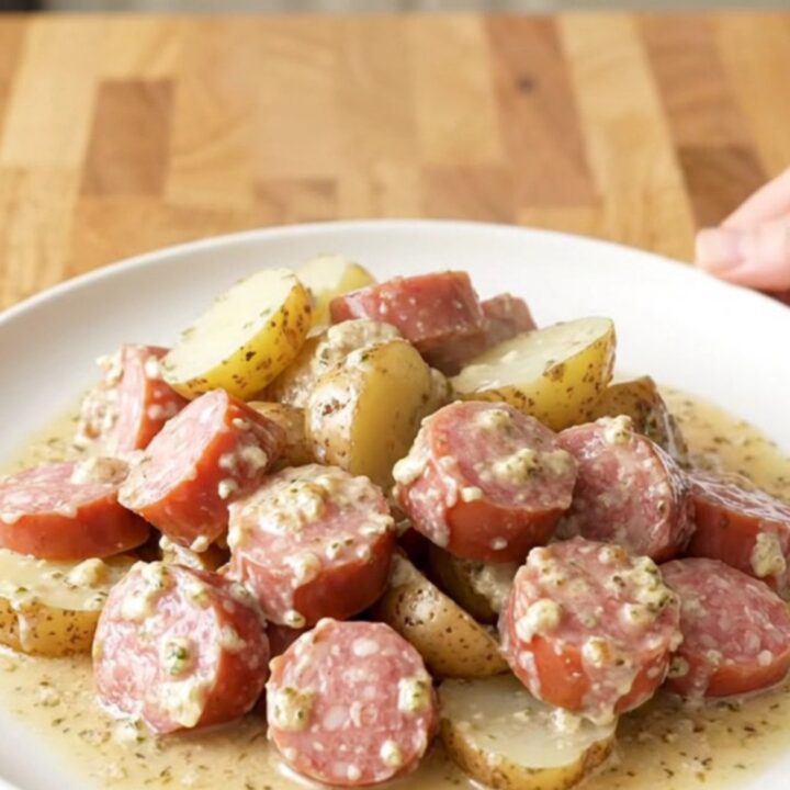 A close-up of creamy garlic Italian sausage and potatoes in a slow cooker.