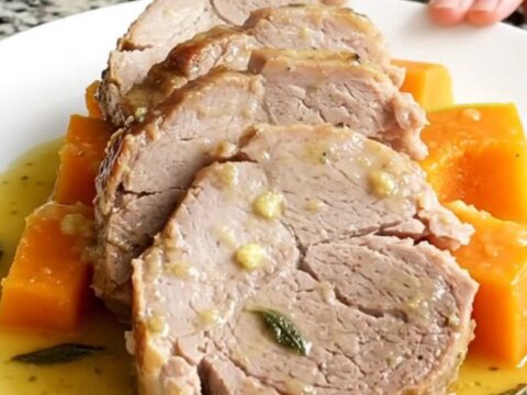A succulent slow cooker pork loin served with tender butternut squash on a white plate.