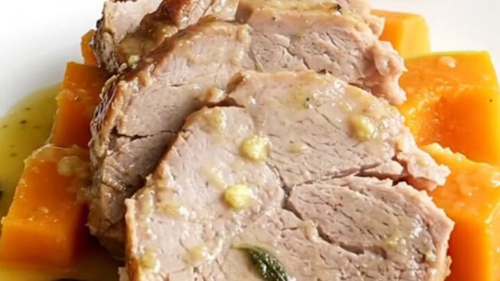 A succulent slow cooker pork loin served with tender butternut squash on a white plate.