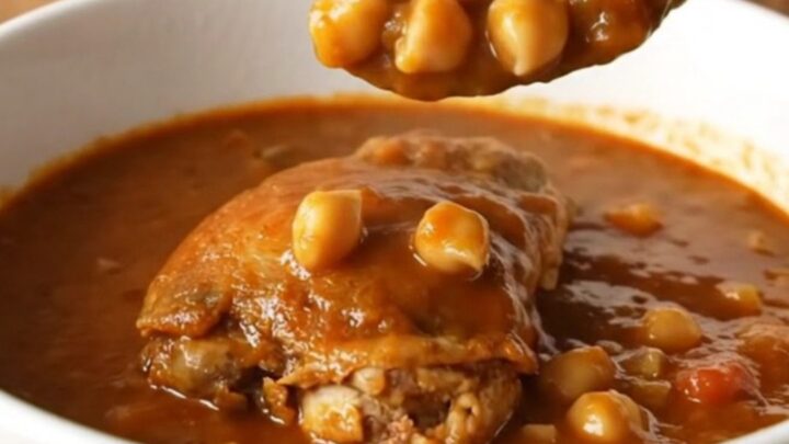 A bowl of smoky chicken and chickpea stew with tender chicken pieces and chickpeas in a vibrant tomato sauce.