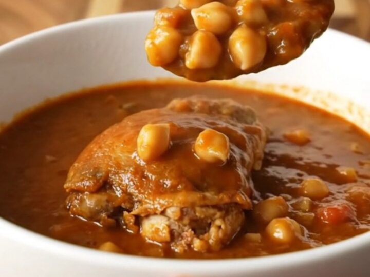 A bowl of smoky chicken and chickpea stew with tender chicken pieces and chickpeas in a vibrant tomato sauce.